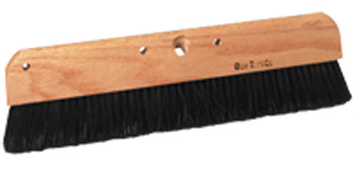 A large broom with a wooden handle and black bristles designed for sweeping.