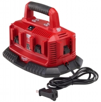 Red battery charger with multiple slots for charging batteries, featuring a handle and power cord.