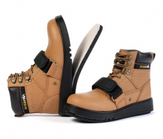 A pair of tan safety boots featuring a high ankle design, lace-up front, and a Velcro strap, set against a white background.