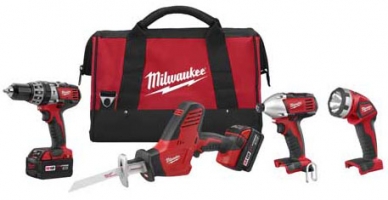 A set of Milwaukee power tools including a drill, reciprocating saw, impact driver, and a flashlight, all arranged with a red tool bag.