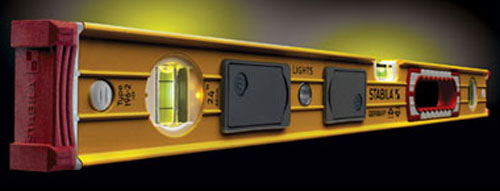 Close-up of a yellow and red spirit level with bubble vials and a light feature, set against a dark background.