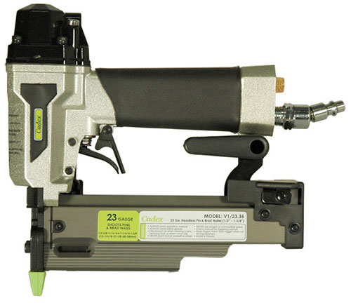 A close-up view of a 23-gauge headless pinner, model V1/23.35, featuring a metallic body, a rubber grip handle, and a green tip for precision nailing.